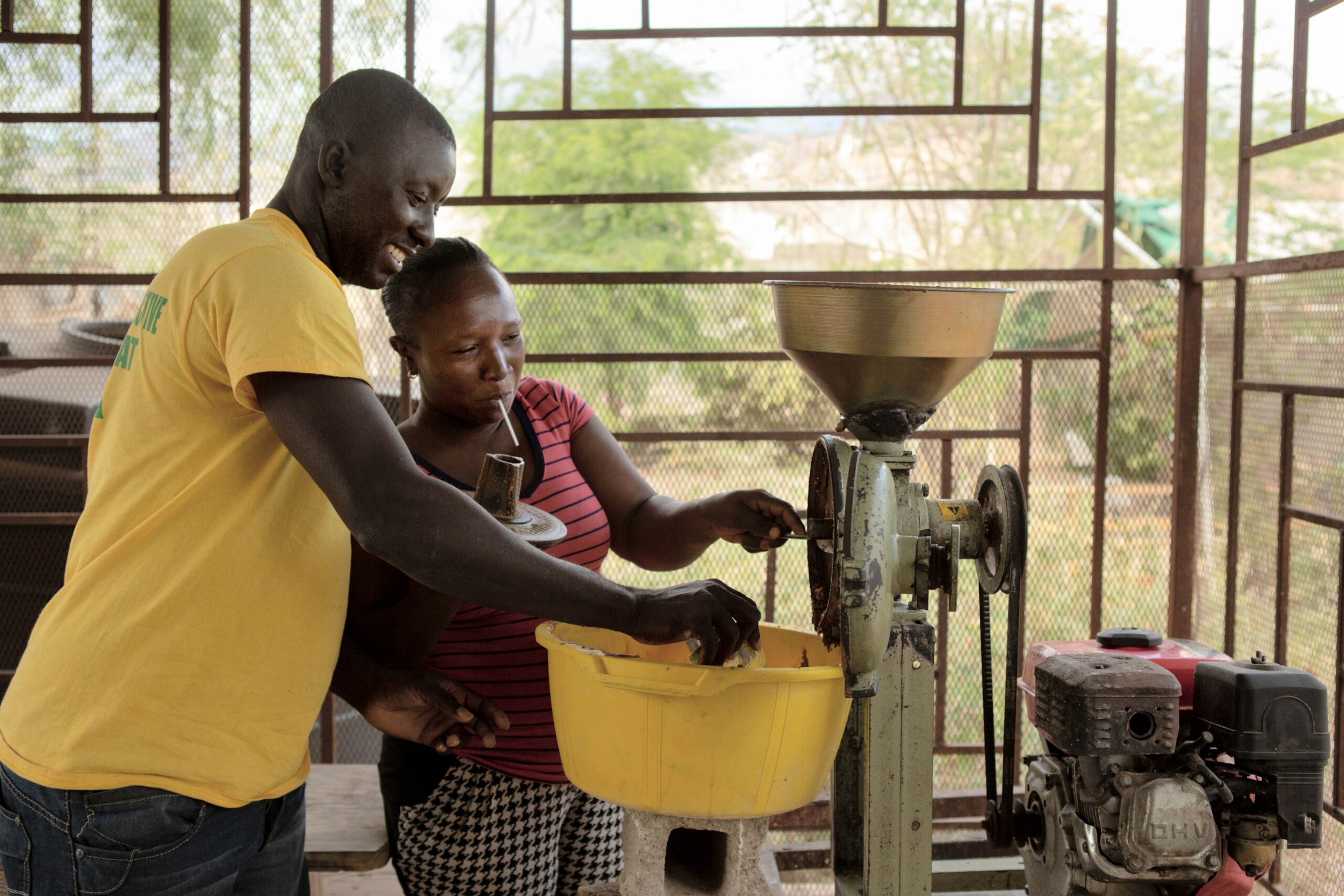 Community organizer Salma Simeus and his wife grind moringa seeds into paste similar to peanut butter, which they then sell, in the Onaville neighborhood of the Canaan settlement outside Port-au-Prince, Haiti, Jan. 6, 2019.