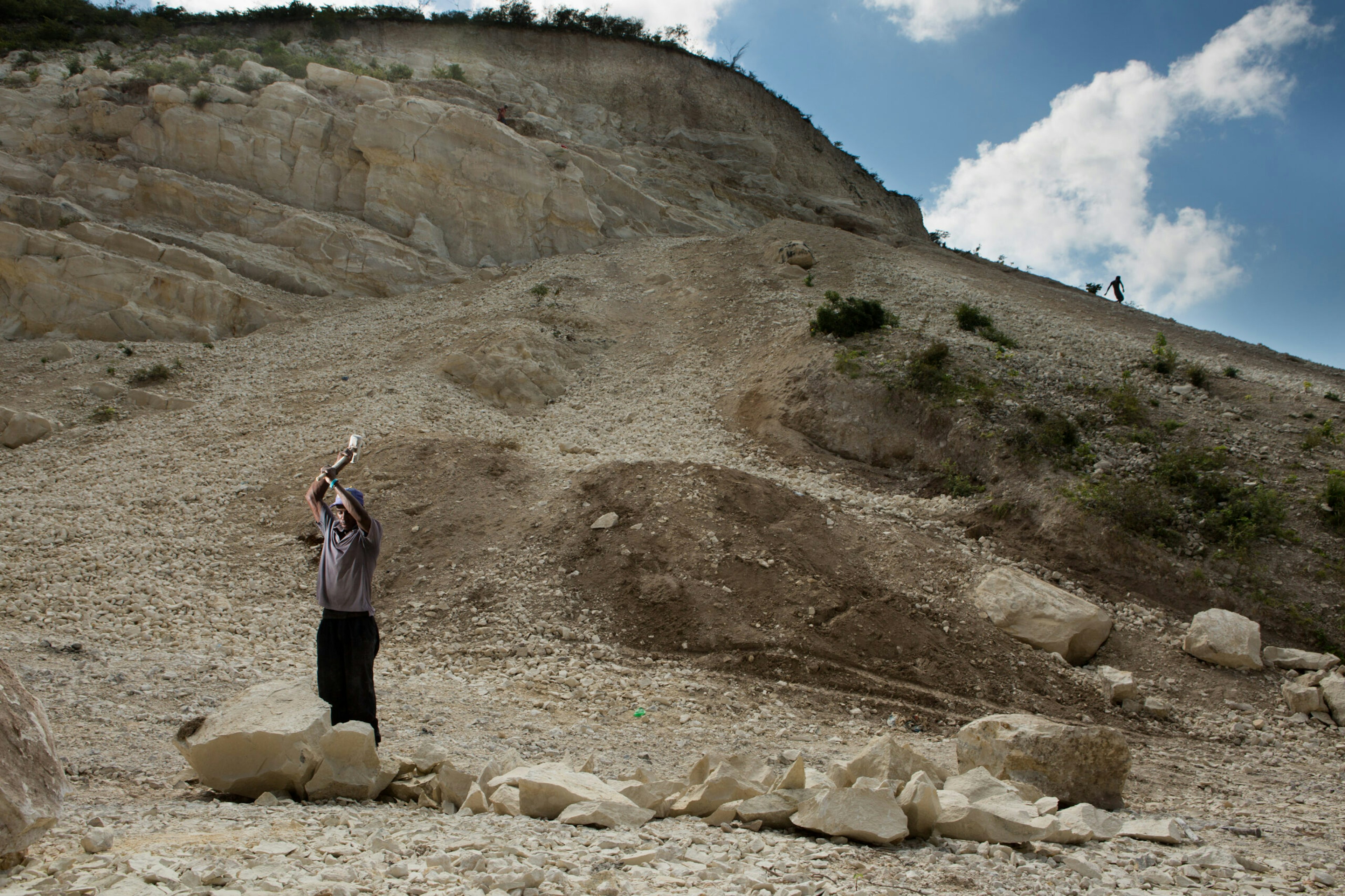 Brandy Harry, left, and Jaleus Wadner, right, both 27, mine for rocks that will be turned into sand and used to construct new buildings, on a mountainside in Canaan, May 12, 2016.