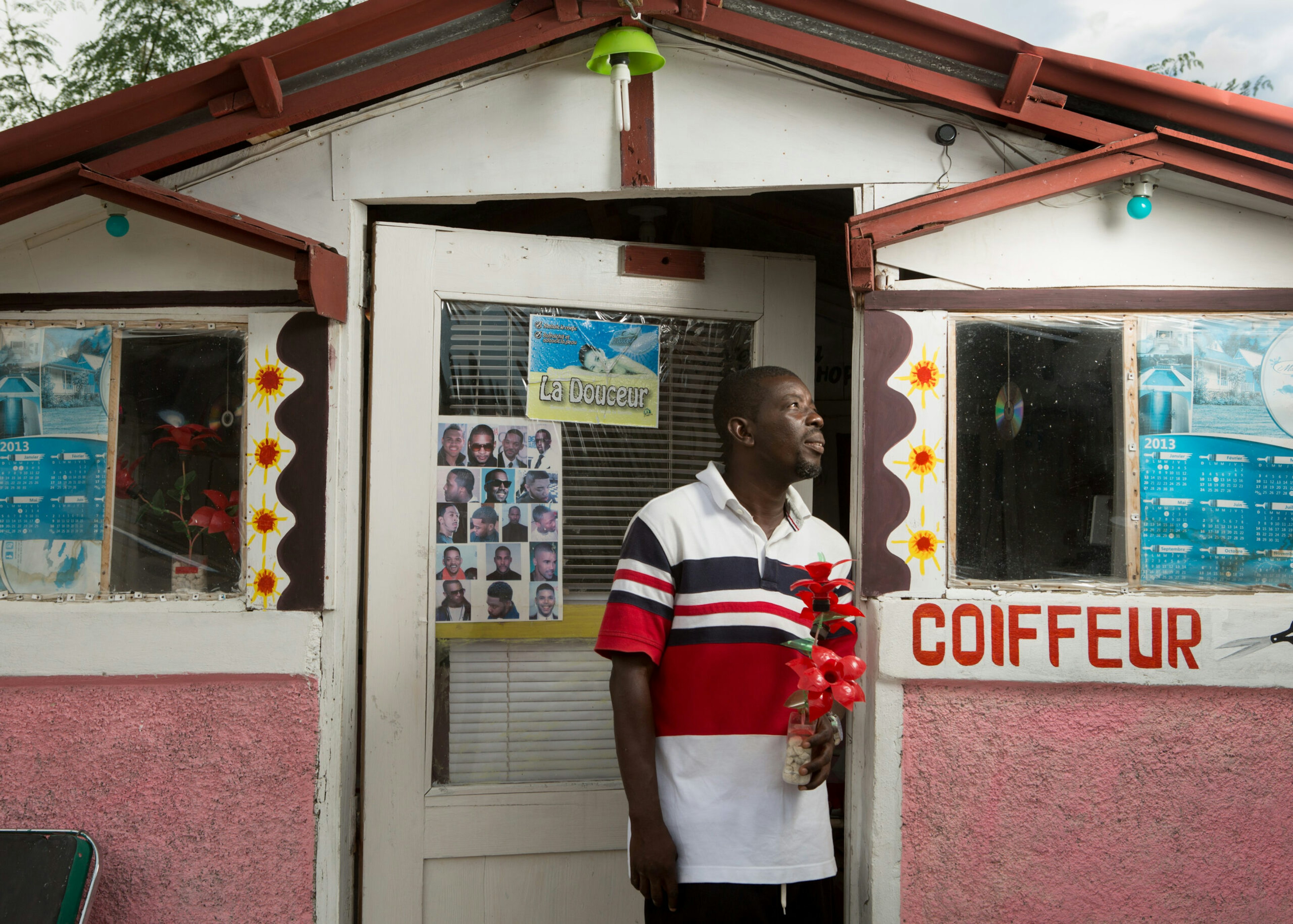 Andre Vernel stands in front of his barber shop in the Onaville section of the Canaan settlement outside Port-au-Prince, Haiti, May 10, 2016.