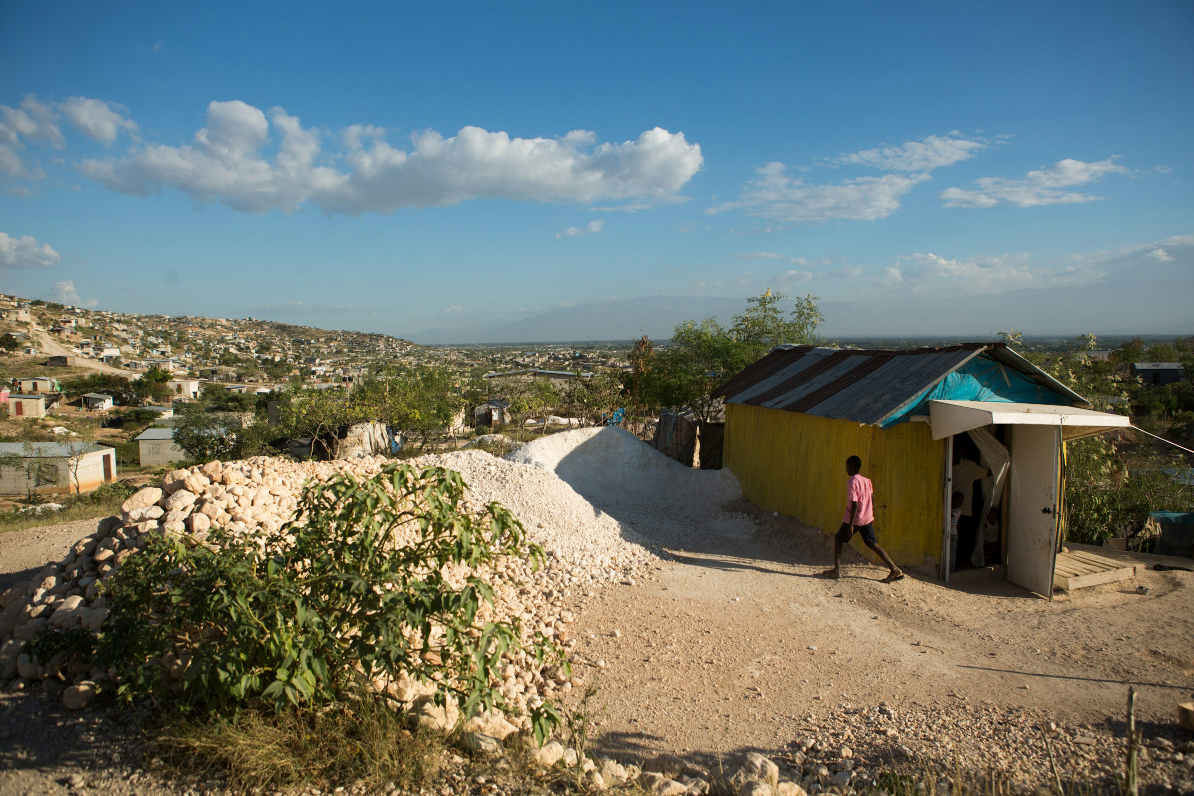 A boy walks past a home in Canaan outside Port-au-Prince, Haiti, Jan. 10, 2015.