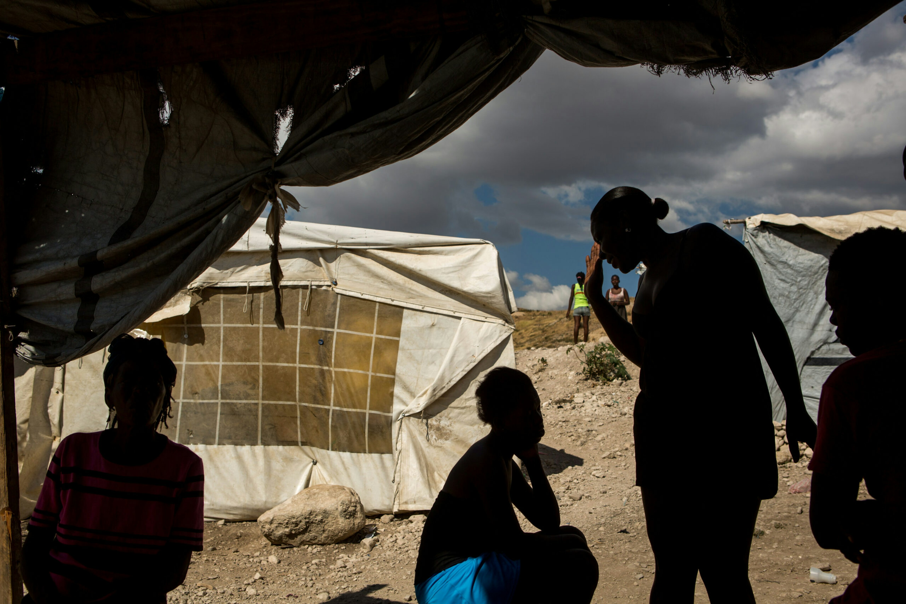 Neighbors visit in the doorways of their tents in St. Christophe in the far northwest area of Canaan, Jan. 10, 2015.