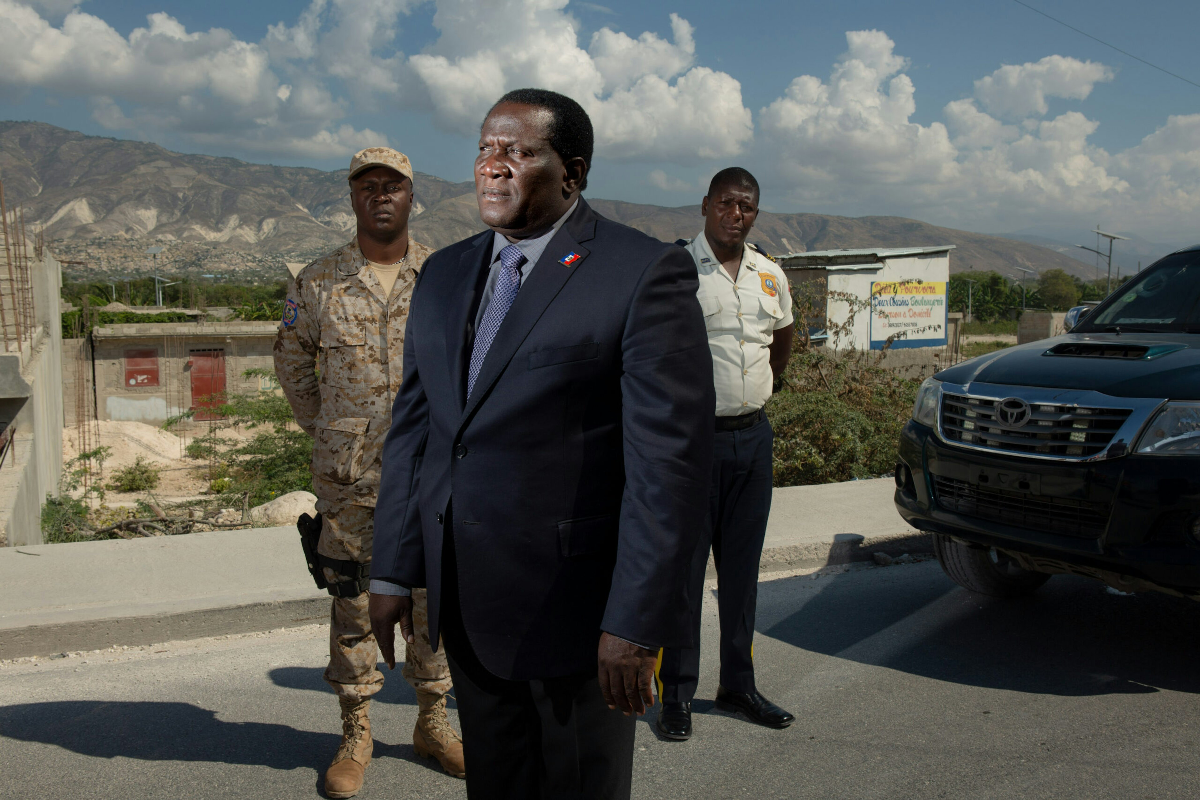 Rony Colin, then-mayor of Croix-des-Bouquets, Haiti, poses for a photo along Canaan’s new road with his security detail — bodyguard Wilio Bellevue, left, and Mikelson Mathurin, Jan. 11, 2019.