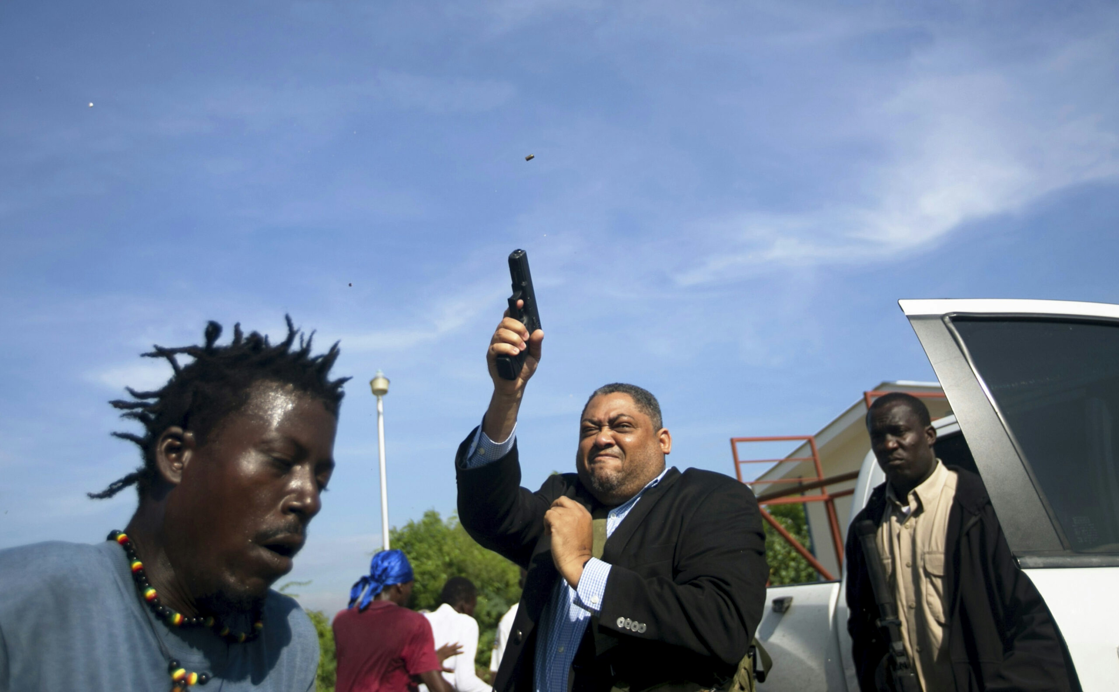 Ruling party Sen. Ralph Féthière fires his gun outside Parliament as he arrives for a vote on the ratification of Fritz William Michel’s nomination as prime minister in Port-au-Prince, Haiti, Sept. 23, 2019.