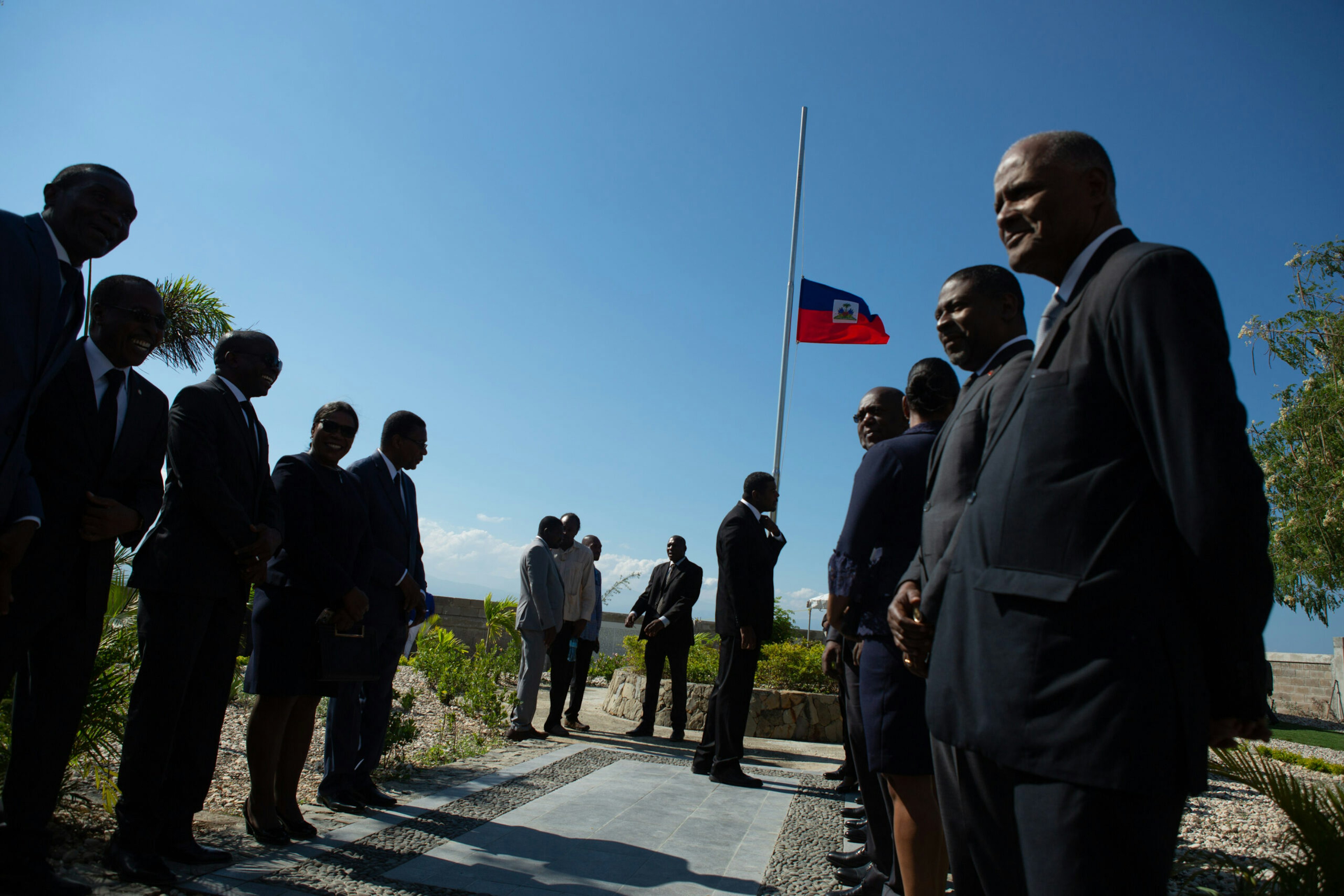 A flag flies at half-mast as dignitaries gather for a wreath-laying ceremony at the St. Christophe memorial just north of Port-au-Prince, Haiti, the mass gravesite where tens of thousands of earthquake victims are buried, on the ninth anniversary of the earthquake, Jan. 12, 2019.