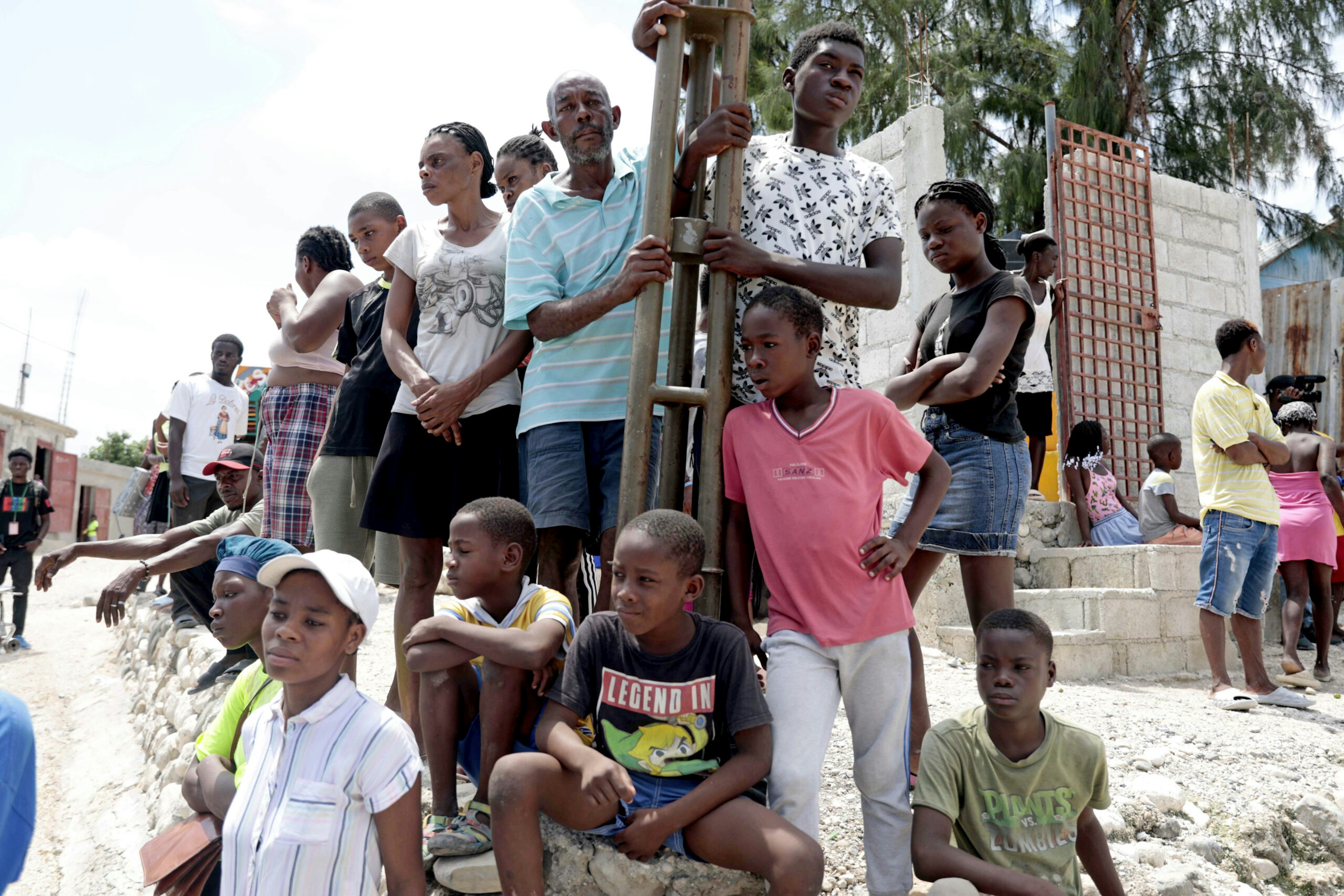 Locals stand by after people were killed during a religious march against a criminal gang in Canaan, Aug. 27, 2023. The powerful gang opened fire on a large group of parishioners as they marched through the community, led by a pastor and armed with machetes, in an attempt to rid the area of its presence.